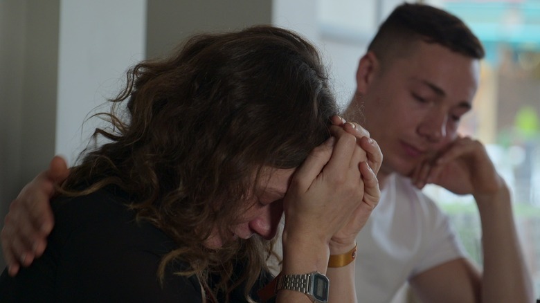 a young man is comforting a crying woman