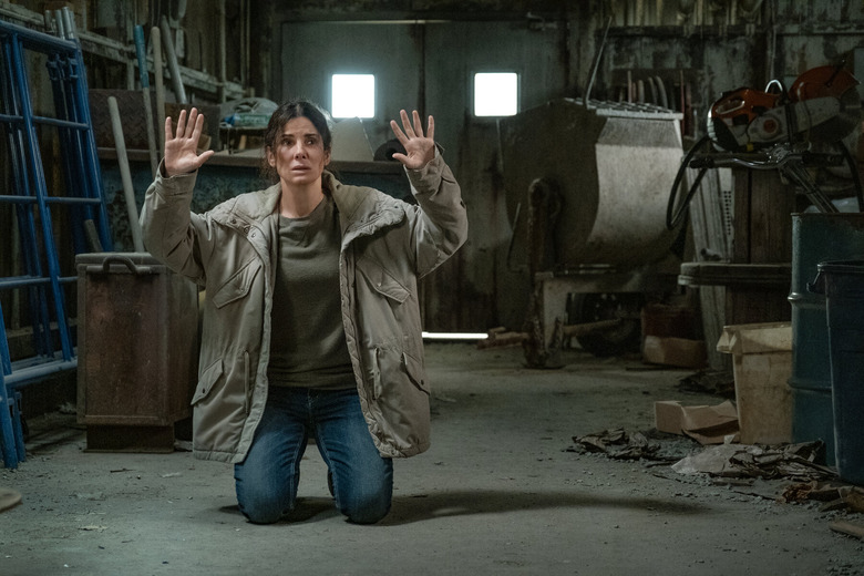 sandra bullock on her knees with hands up