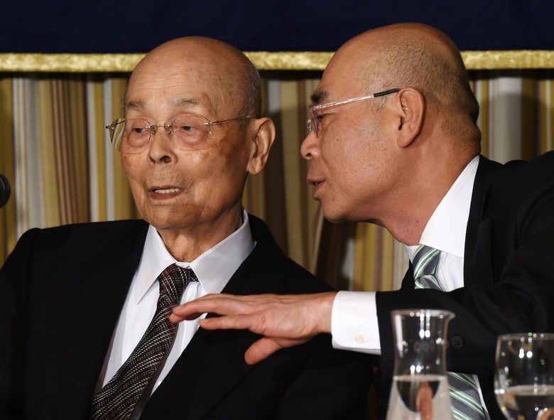 Sushi chef Jiro Ono listens to his son, Yoshikazu, during a press conference in Tokyo