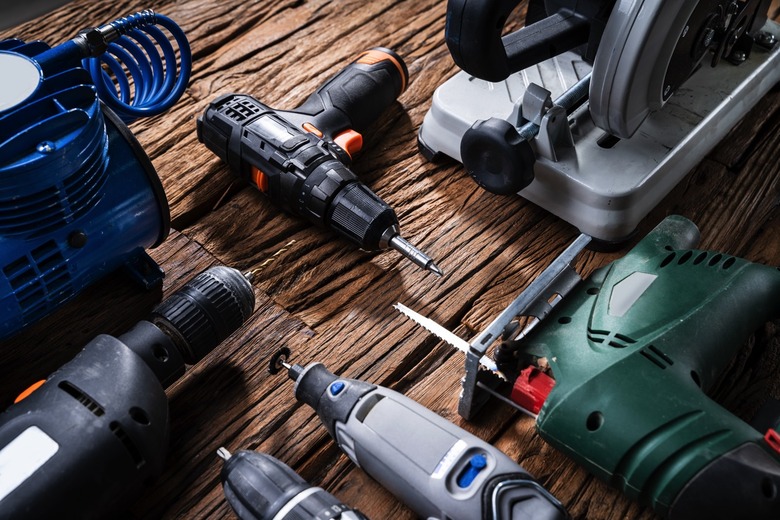 A collection of power tools on a wooden desk.