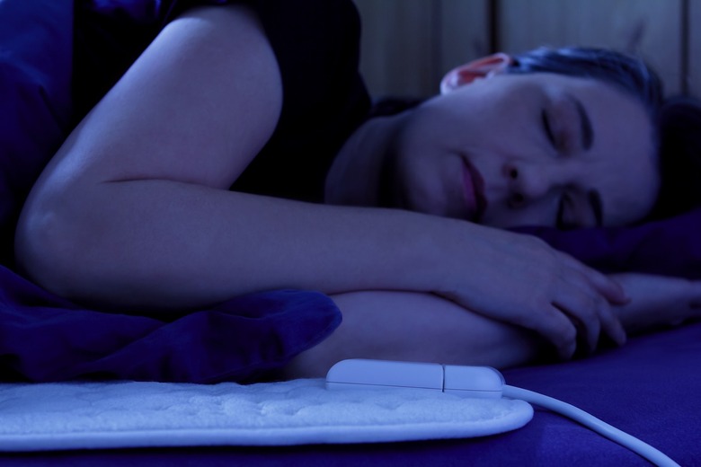 Woman sleeping on an electric heated blanket.