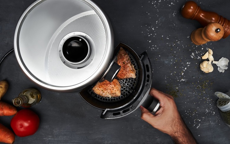 A person using an air fryer.