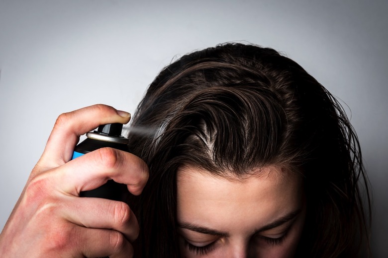 A person applying dry shampoo hair