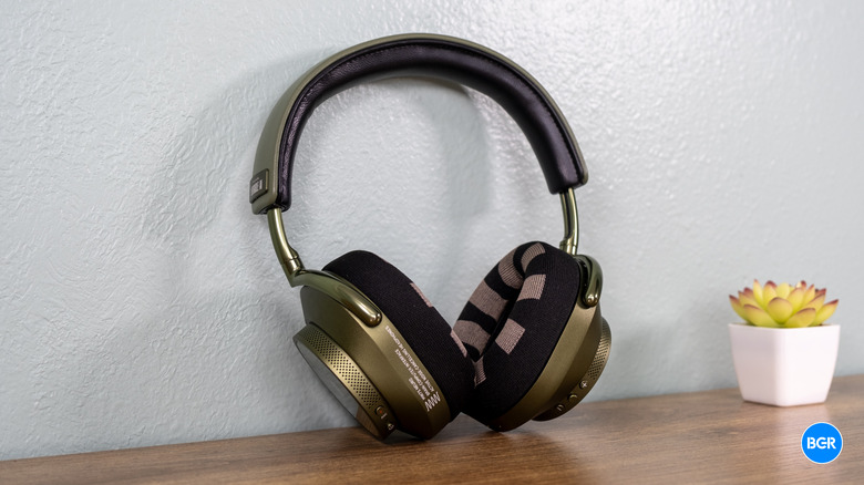 Green Master & Dynamic MW75 Neuro headphones on a table.