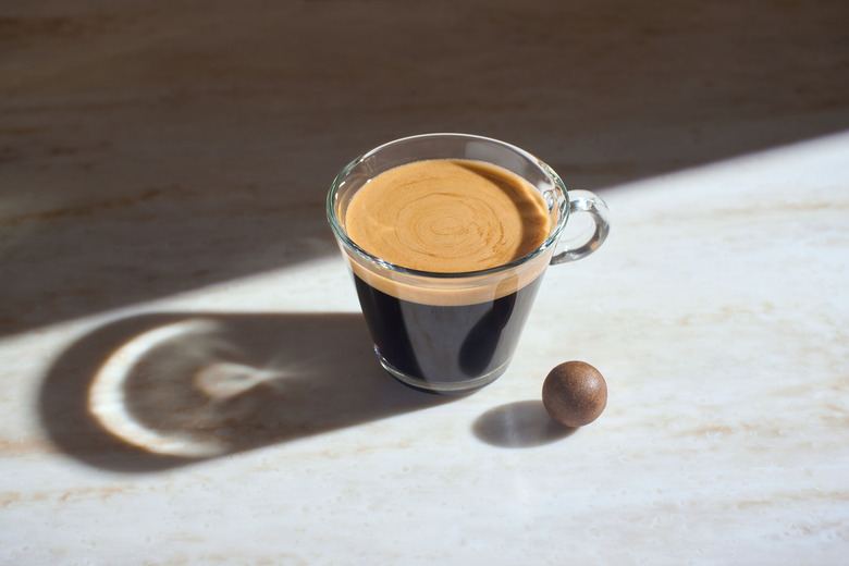 CoffeeB compostable coffee ball next to cup