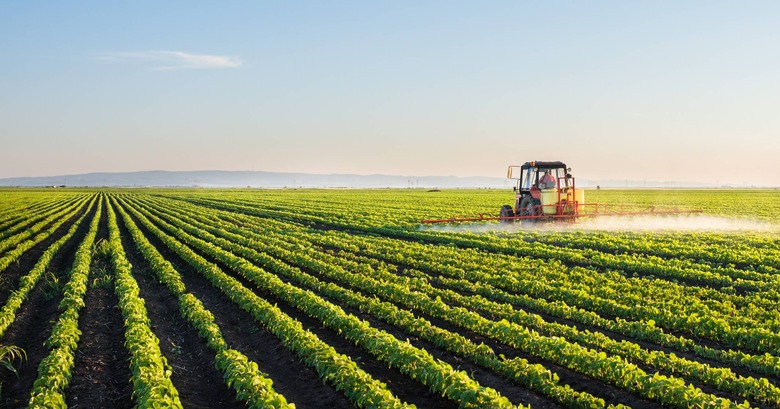 farmland with tractor fertilizing field