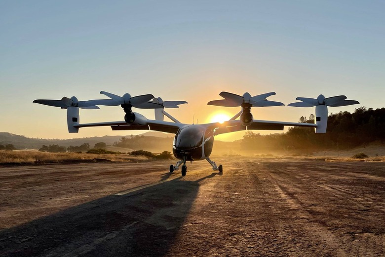 Flying taxi on ground waiting to take off, sunset behind it
