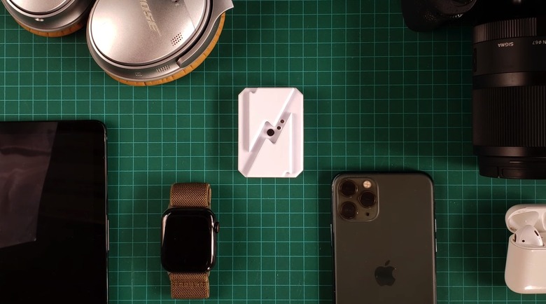 Charge-Check battery health gadget surrounded by battery-powered devices.