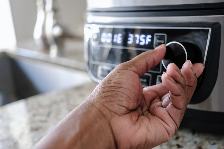 Adjusting the temperature on an air fryer.