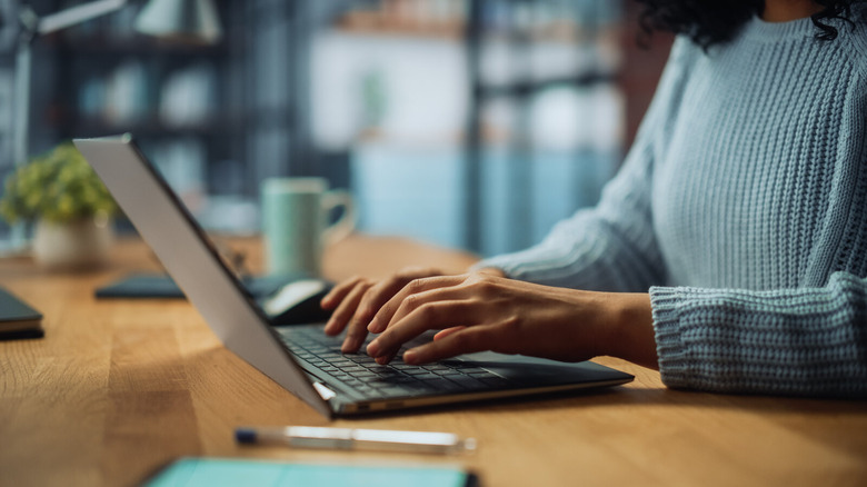 Close Up on Hands of a woman Working on Laptop Computer