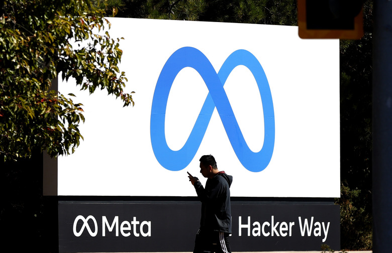 A pedestrian walks in front of the name 'Meta' on the sign in front of Facebook headquarters on October 28, 2021, in Menlo Park, California.