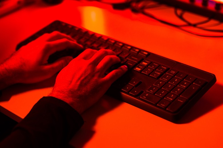 Hacker stealing information on a computer keyboard.