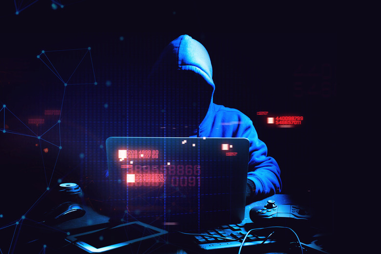 A hacker hides in the shadows with computer code illustration