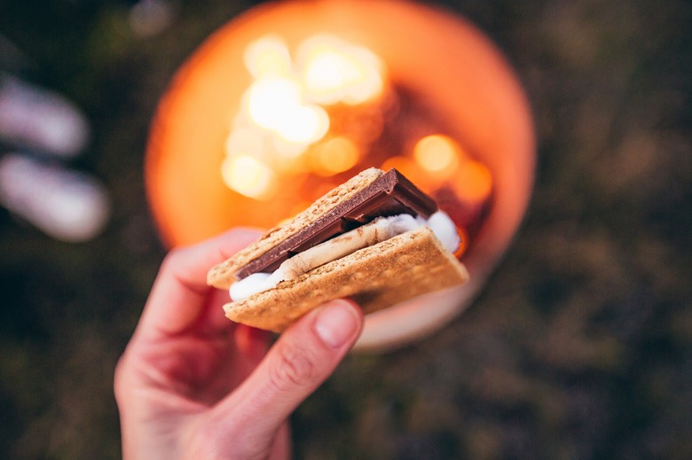 Holding s'more over a campfire.